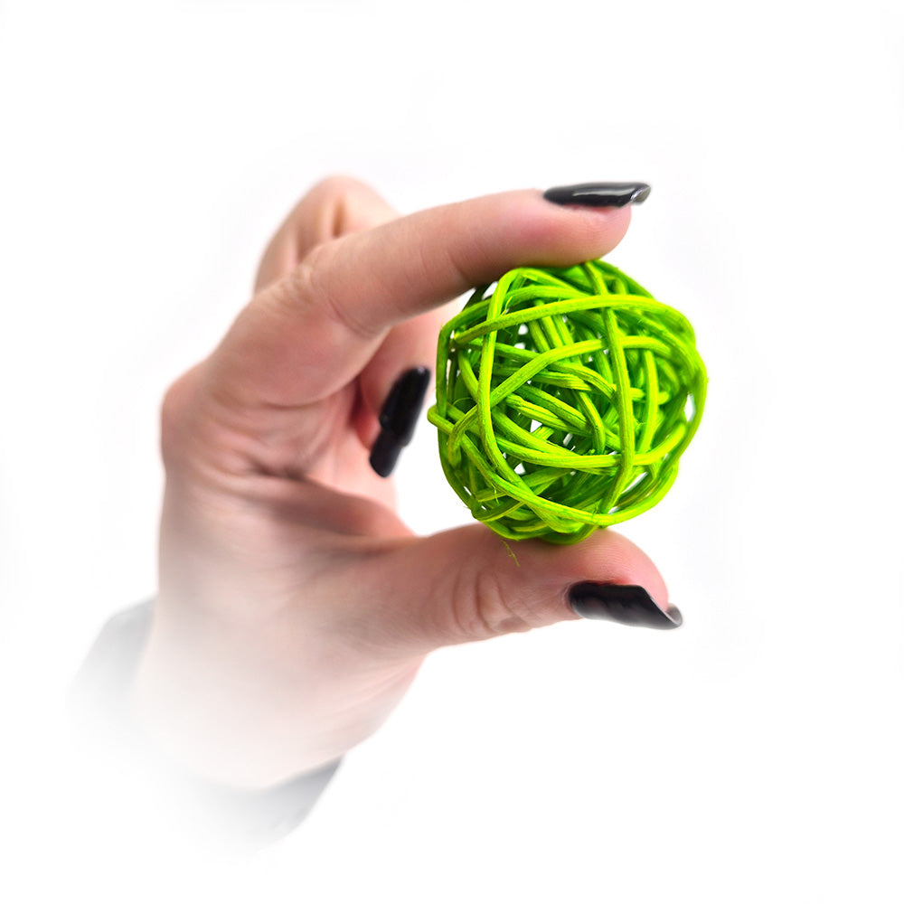 Eduk8 bright green rattan sensory ball held between fingers – lightweight tactile resource ideal for sensory play and fine motor skill development.