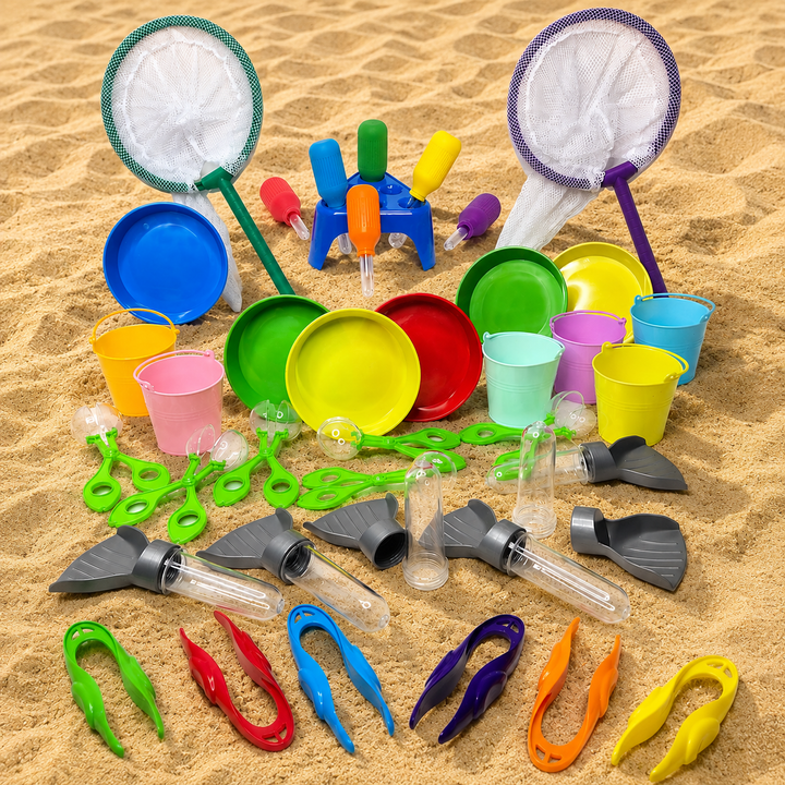 A colourful beach toy set arranged on sand, including two large mesh nets, multiple plastic buckets and cups, small scoop tools, tongs, and other sand play accessories in bright rainbow colours. Sand and Water play Kit